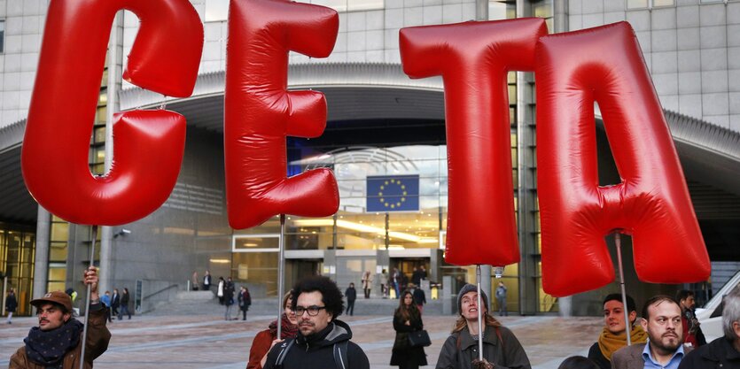 Demostranten halten die Buchstaben C E T A hoch