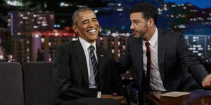 Barack Obama sitzt lachend links vom Moderator, der sich zu ihm beugt und ihm etwas erzählt