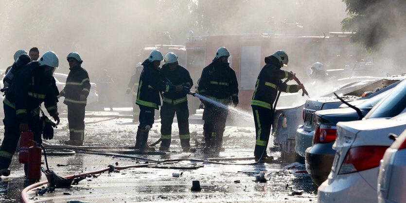 Feuerwehrleute im Einsatz auf einem Parkplatz