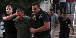 Zwei türkische Polizisten führen einen Mann ab
