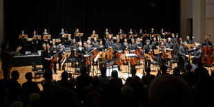 Die Dresdner Sinfoniker hell erleuchtet in einem sonst dunklen Raum