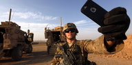 Soldat in der Wüste, der ein Selfie von sich macht - mit einem IPhone
