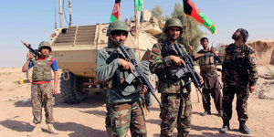 Afghanische Sicherheitskräfte stehen bewaffnet vor einem Panzer