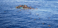 Menschen auf einem gekenterten Boot. Andere schwimmen im Wasser