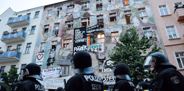 Polizisten stehen vor dem besetzten Haus in der Rigaer Straße