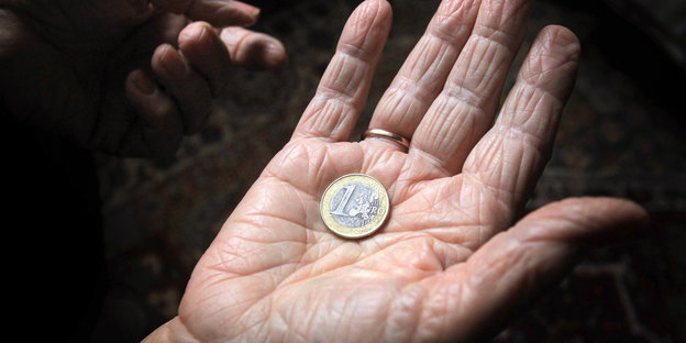 Euro-Münze in der Hand einer 83-Jährigen