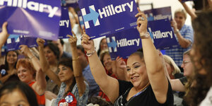 Hispanic-Frauen halten Schilder in die Luft mit „Hillary“