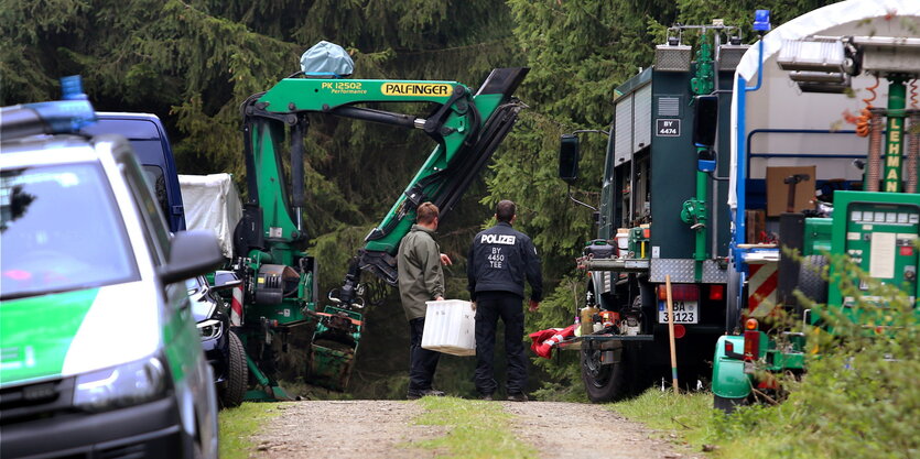 Polizisten mit Maschinen im Wald