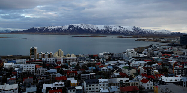 Häuser von Reykjavik, dahinter eine Bucht und darüber bewölkter Himmel