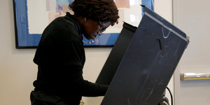Eine Frau steht in einer Wahlkabine