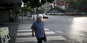 Eine Frau geht durch die leeren Straßen von Caracas