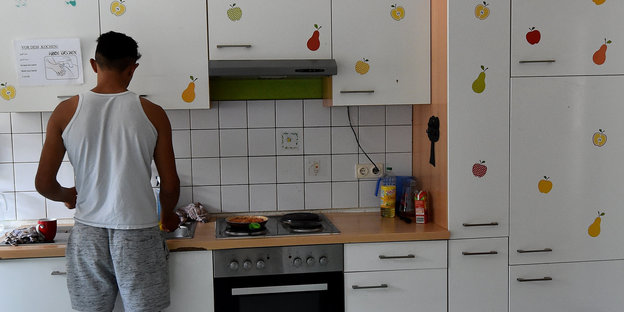 Ein Jugendlicher aus kocht in einer Unterkunft für unbegleitete Flüchtilinge