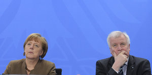 Angela Merkel und Horst Seehofer sitzen nebeneinander regungslos