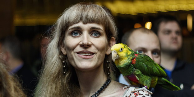 Eine Frau mit einem Papagei auf der Schulter