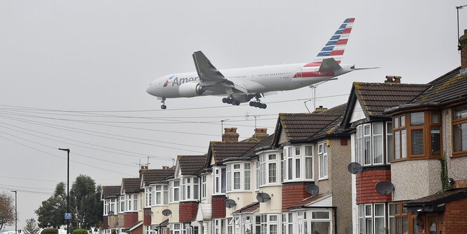 Ein Flugzeug beim Landen über ein paar typischen englischen Reihenhäusern