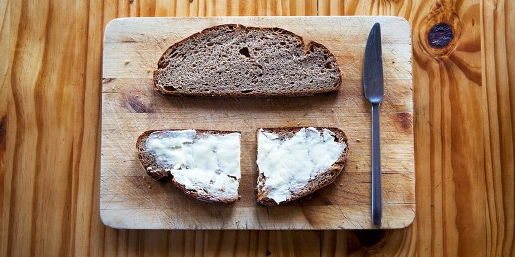 Graubrot mit Butter drauf, akkurat auf dem Tisch angeordnet.