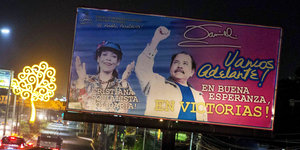 Auf einer Werbetafel ist Daniel Ortega in siegesgewisser Pose zu sehen, daneben seine Frau, die applaudiert