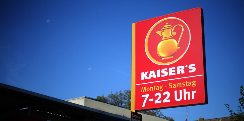 Ein rotes Kaiser's-Schild ragt in den strahlend blauen Himmel