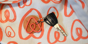 Ein Schlüssel mit einem orangen, dreieckigen Airbnb-Schlüsselanhänger