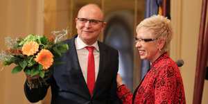 Erwin Sellering hält Blumen steht neben Sylvia Bretschneider