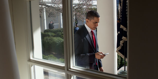 Barack Obama blickt auf sein Smartphone