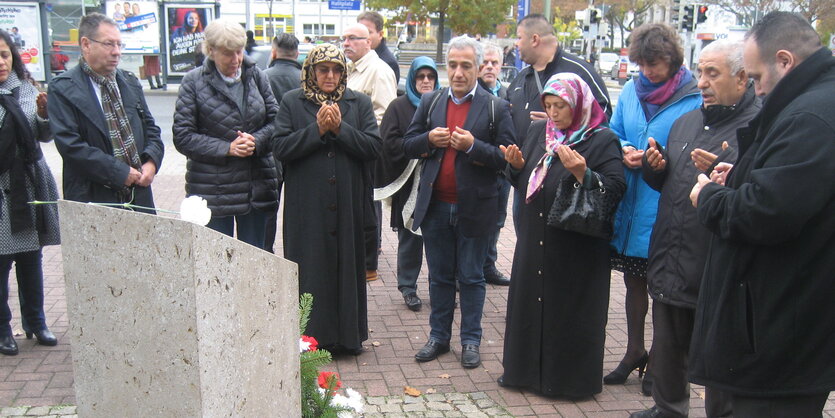 Viele Menschen vor einem Gedenkstein