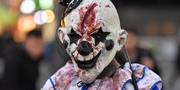 Ein als Clown verkleideter Mensch mit blutverschmierter Maske