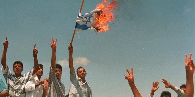 Palästinensische Jugendliche verbrennen eine israelische Flagge