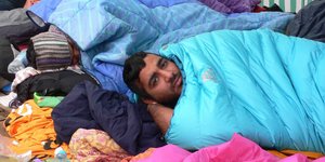 Der Flüchtling Adeed Ahmed liegt in einem Schlafsack neben anderen auf dem Boden