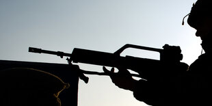 Schwarze Silhouette eines Soldaten, der sein Gewehr hält