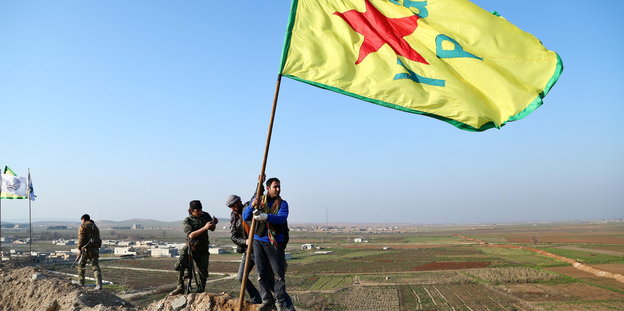 YPG-Kämpfer schwenken ihre Fahne nach der Befreiuung Kobanes