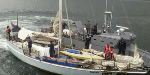 Auf einem Segelschiff stehen mehrere Menschen