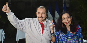 Daniel Ortega und seine Frau zeigen den Daumen nach oben, auf diesem ist Stempelfarbe