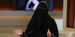 Die mit einem Niqab vollverschleierte Nora Illi sitzt im Studio von Anne Will und hebt beim Sprechen die Hände