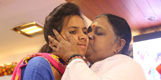 Mata Amritanandamayi küsste eine Anhängerin