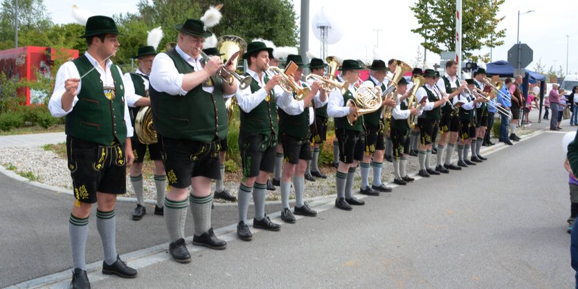 Eine bayerische Blaskapelle in Trachtenkleidung mit Lederhosen und Hüten