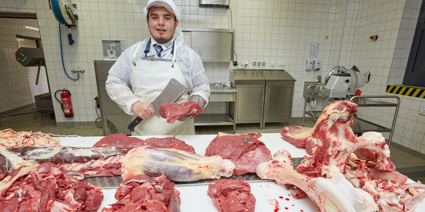 Fleischergeselle mit zerlegtem Rind