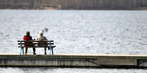 Zwei ältere Menschen auf einer Bank am See