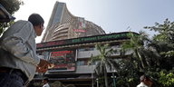 Ein Mann steht vor dem Gebäude des BSE in Mumbai und schaut in dessen Richtung