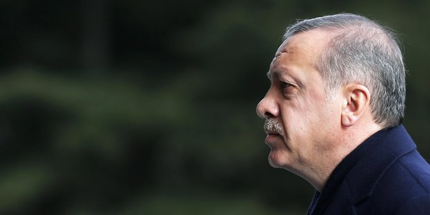 Erdoğan steht rechts im BIld und schaut nach links