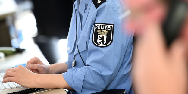 Polizeibeamtin sitzt am Computer