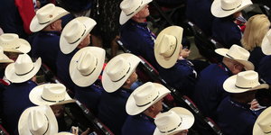 Viele sitzende Männer mit Cowboyhüten