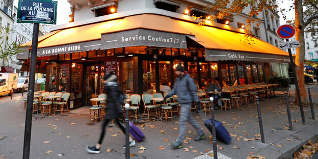 Menschen laufen an der Bar „À la bonne bière“ in Paris vorbei Menschen laufen an der Bar „À la bonne bière“ in Paris vorbei