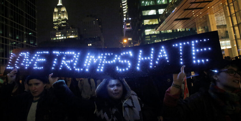 Menschen protestieren in New York mit dem leuchtenden Schriftzug "Love Trumps Hate" nach der Wahl Donald Trumps zum US-Präsidenten