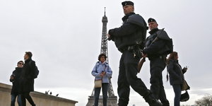 Polizisten und Touristen vor dem Eiffelturm in Paris