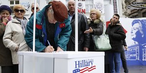 Menschen an einem Wahlkampfstand für Hillary Clinton