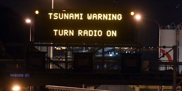auf einem elektronisches Straßenschild steht „Tsunami Warning Turn Radio On“