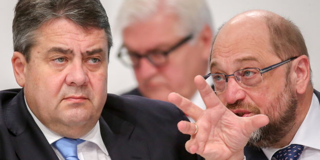 Sigmar Gabriel und Martin Schulz unterhalten sich, im Hintergrund sitzt Frank-Walter Steinmeier