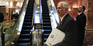 Mike Pence steht vor einer Rolltreppe
