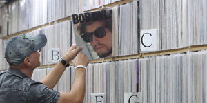 Ein Kunde zieht in Seoul in einem Musikgeschäft eine Schallplatte von Bob Dylan aus dem Regal